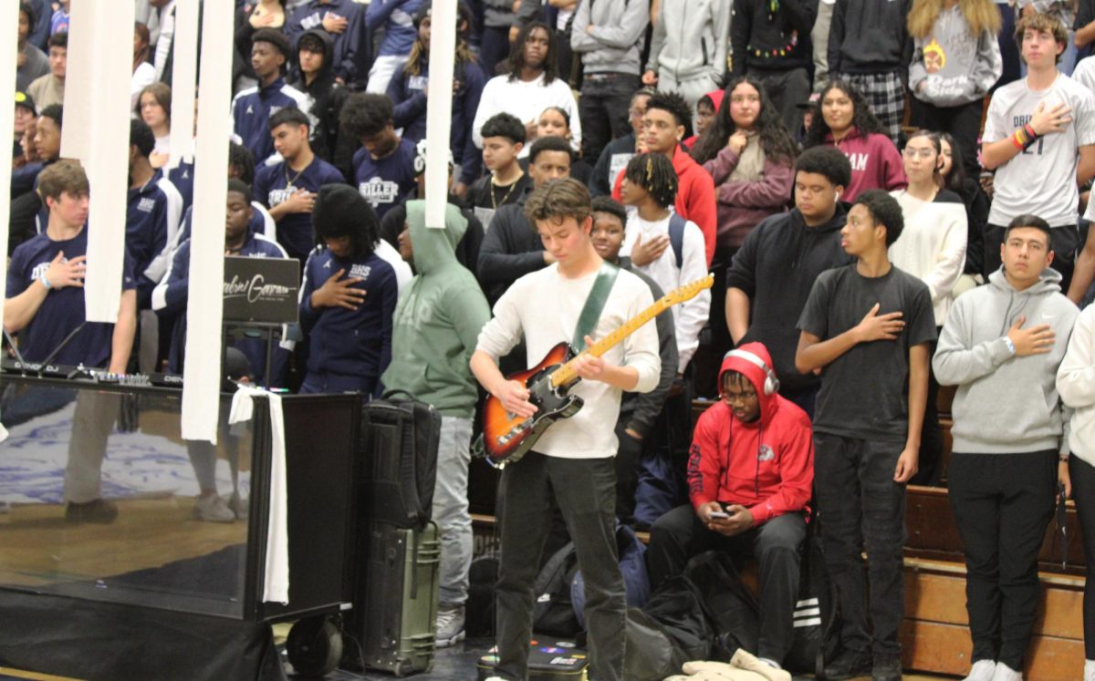 Ethan Walker performs the national anthem on his electric guitar.